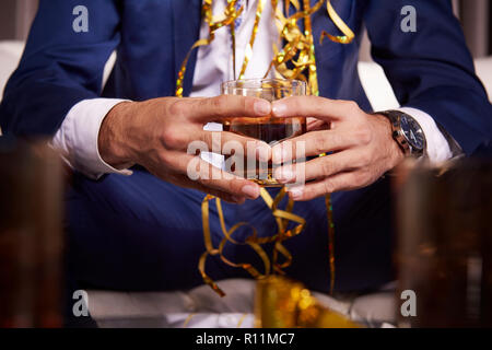 Unrecognizable man holding glass of whiskey Foto Stock