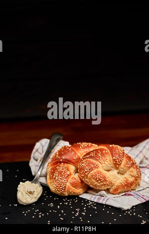 Appena fatti bun laminati con formaggio fresco sulla pietra nera tagliere e cosparsi di semi di sesamo. Molto leggera profondità di campo Foto Stock