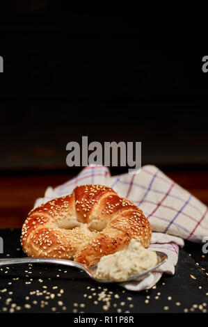 Appena fatti bun laminati con formaggio fresco sulla pietra nera tagliere e cosparsi di semi di sesamo. Molto leggera profondità di campo Foto Stock