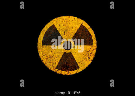Round di giallo e nero radioattivo (radiazioni ionizzanti) pericolo nucleare simbolo sul metallo arrugginito grungy texture e isolate su nero scuro dello sfondo. Foto Stock