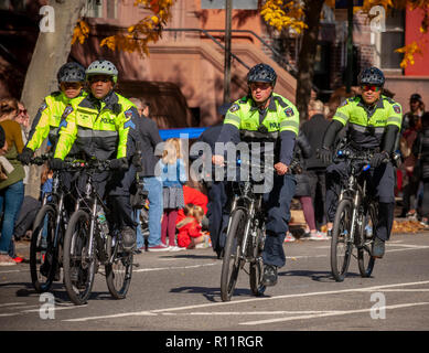 Ufficiali di NYPD montati su biciclette passano attraverso Harlem in New York vicino al 22 mile mark vicino a Mount Morris Park domenica 4 novembre 2018 nel 48th annuale di TCS New York City Marathon. Circa 50.000 corridori provenienti da oltre 120 Paesi competono in gara, la più grande del mondo di maratona. (© Richard B. Levine) Foto Stock