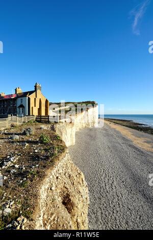 Old coastguard cottages sul bordo di chalk cliffs, mostrando erosione costiera a Birling Gap East Sussex England Regno Unito Foto Stock