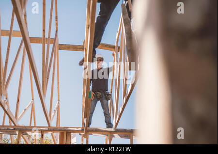 Costruttori lavorando sul telaio sul tetto dell'edificio Foto Stock