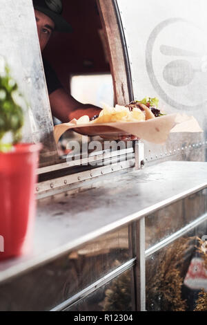 Il cibo viene servito attraverso la finestra di camper van cibo carrello Foto Stock