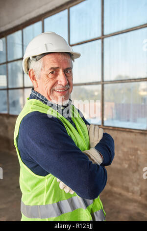 Senior come un fiducioso logistica lavoratore con bracci incrociati Foto Stock