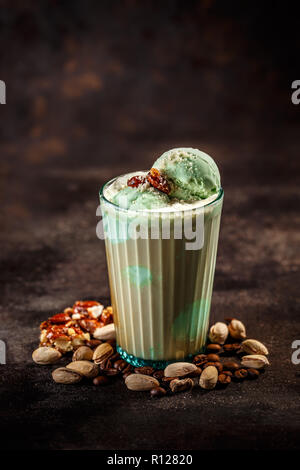 Caffè latte con pistacchio gelati su sfondo scuro Foto Stock