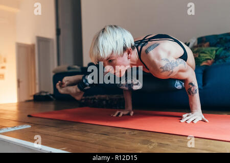 La donna a praticare yoga a casa Foto Stock