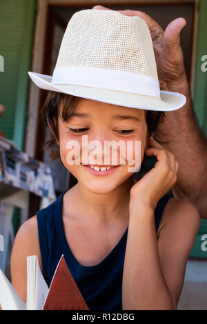 Nonno immissione hat sul ragazzo del capo Foto Stock