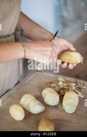 La donna la pelatura di patate per gnocchi Foto Stock