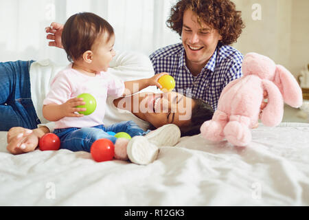 La famiglia felice giocando con il bambino in camera. Giovane madre e Foto Stock