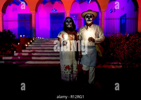 Merida, Cementerio generale, Messico - 31 Ottobre 2018: Customed uomo e donna con messicano con tradizionali vestiti di bianco e il cranio di make-up nella parte anteriore del Foto Stock