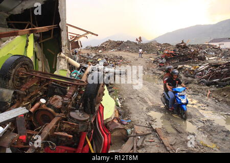 Si vedono persone che passa in corrispondenza del sito dove il terremoto è accaduto. Un mortale terremoto di magnitudo 7.5 grandezza e un maremoto distrusse la città di Palu e gran parte dell'area di Sulawesi centrale. Il numero di morti è stato 2088, circa 5000 persone sono state gravemente ferite e alcuni 62.000 persone sono state sfollate. Foto Stock