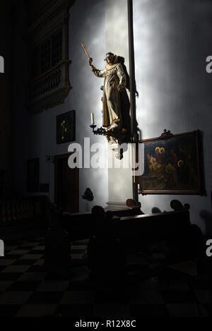 08 novembre 2018, Renania settentrionale-Vestfalia, Düsseldorf: la luce del sole cade attraverso una finestra della chiesa della chiesa cattolica San Maximilian e illumina la figura di un santo appeso alla parete della navata. Foto: Horst Ossinger/dpa Foto Stock