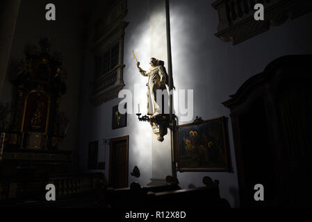 08 novembre 2018, Renania settentrionale-Vestfalia, Düsseldorf: la luce del sole cade attraverso una finestra della chiesa della chiesa cattolica San Maximilian e illumina la figura di un santo appeso alla parete della navata. Foto: Horst Ossinger/dpa Foto Stock