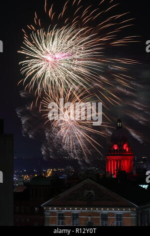 Leeds 8 novembre 2018. Fuochi d'artificio dal Leeds Interruttore Luci su illuminano il cielo notturno dietro Leeds Town Hall illuminato di rosso per il Leeds International Film Festival. Foto Stock