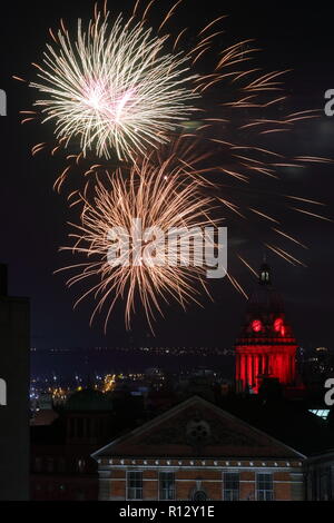 Leeds 8 novembre 2018. Fuochi d'artificio dal Leeds Interruttore Luci su illuminano il cielo notturno dietro Leeds Town Hall illuminato di rosso per il Leeds International Film Festival. Foto Stock