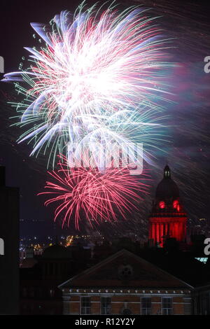 Leeds 8 novembre 2018. Fuochi d'artificio dal Leeds Interruttore Luci su illuminano il cielo notturno dietro Leeds Town Hall illuminato di rosso per il Leeds International Film Festival. Foto Stock