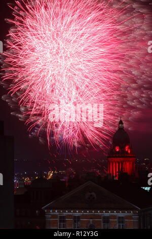 Leeds 8 novembre 2018. Fuochi d'artificio dal Leeds Interruttore Luci su illuminano il cielo notturno dietro Leeds Town Hall illuminato di rosso per il Leeds International Film Festival. Foto Stock