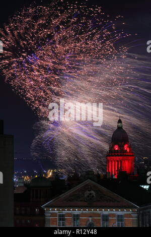 Leeds 8 novembre 2018. Fuochi d'artificio dal Leeds Interruttore Luci su illuminano il cielo notturno dietro Leeds Town Hall illuminato di rosso per il Leeds International Film Festival. Foto Stock