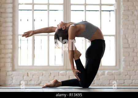 Giovane sportivo da donna yogi la pratica dello yoga, facendo la posa del cammello Foto Stock