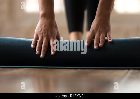 Vista frontale delle mani femminili di piegatura esercizio blu mat Foto Stock