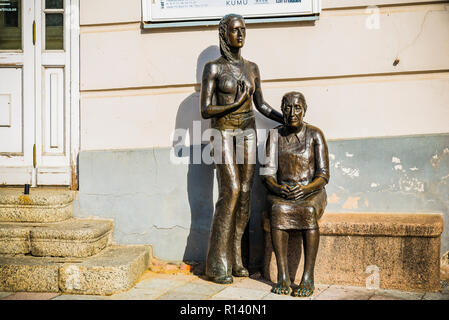 Le donne di campagna, di fronte alla galleria d'arte. Giovane donna indossa il jeans svasata e mancanza di Bra. Tartu, Contea di Tartu, Estonia, Baltico stat Foto Stock