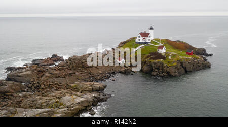 Il rosso faro di luce Nubble avverte i naviganti di rocce pericolose e navigare sull'Oceano Atlantico Costa Orientale Foto Stock