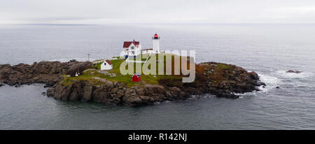 Il rosso faro di luce Nubble avverte i naviganti di rocce pericolose e navigare sull'Oceano Atlantico Costa Orientale Foto Stock