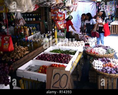 BINANGONAN, Rizal, Filippine - 8 Novembre 2018: una frutta e verdura vende fornitore di prodotti freschi presso un mercato pubblico. Foto Stock