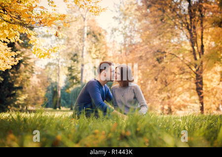 L'uomo whispering nella donna di orecchio Foto Stock