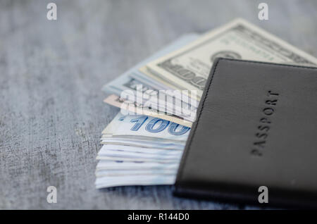 In cuoio rivestito di un passaporto in corso di validità e di contanti in lire e banconote di dollari sul tavolo.Copia dello spazio. Foto Stock