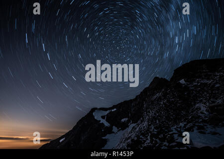 Cielo notturno tracce stellari sopra Aiguille de Bionnassay montagna, alpi, Francia Foto Stock