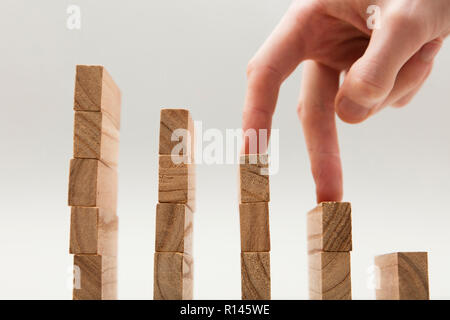 Persone mano a camminare su un insieme di blocchi di legno. Lo sviluppo del business e il concetto di crescita Foto Stock