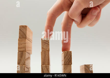 Persone mano a camminare su un insieme di blocchi di legno. Lo sviluppo del business e il concetto di crescita Foto Stock