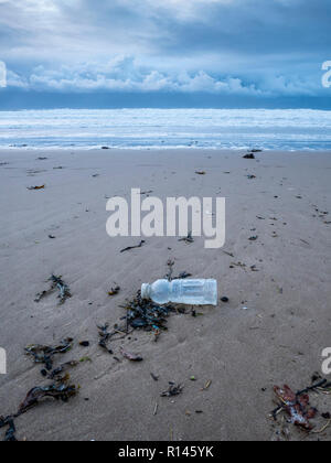 Un scartato la bottiglia di plastica su una spiaggia nel Regno Unito parte della plastica inquinamento e problemi ambientali Foto Stock