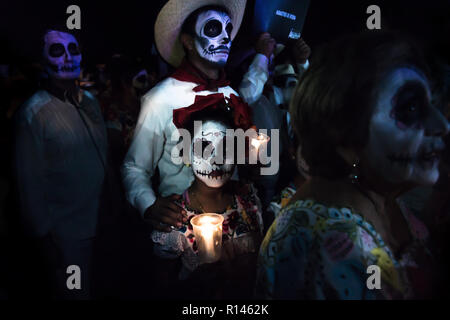 Merida, Cementerio generale, Messico - 31 Ottobre 2018: Customed ai partecipanti della sfilata con cranio make-up, con un cowboy uomo e bambino con fiori un Foto Stock