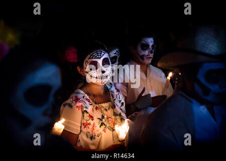 Merida, Cementerio generale, Messico - 31 Ottobre 2018: Donna con il cranio e la ragnatela di make-up e condire con la tradizionale messicano fiori circondata da Foto Stock