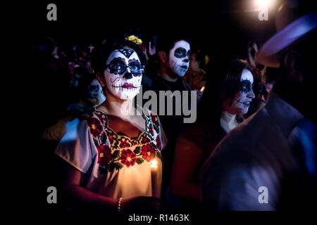 Merida, Cementerio generale, Messico - 31 Ottobre 2018: Donna con il cranio e la ragnatela di make-up e bicchieri e condire con la tradizionale messicano fiori su Foto Stock