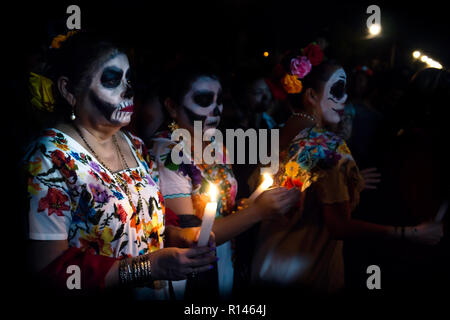 Merida, Cementerio generale, Messico - 31 Ottobre 2018: Tre customed donna vestita come Catrinas con cranio make-up avendo problemi con le candele scommessa Foto Stock