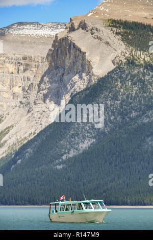 BANFF, AB, Canada - Giugno 2018: vista panoramica di una piccola imbarcazione turistica sul Lago Minnewanka vicino a Banff passato di crociera di alta montagna. Foto Stock