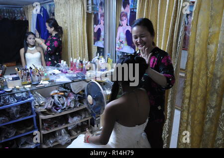 Sposa cambogiano, w/ parrucchiere, ottenere pronto per un matrimonio Khmer che indossa un tradizionale occidentale abito da sposa. Phnom Penh Cambogia. © Kraig Lieb Foto Stock