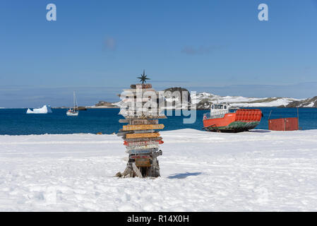 Cartello di direzione con la distanza di diverse città in russo Bellingshausen Antarctic Research Station, sull'isola King George, in Antartide Foto Stock