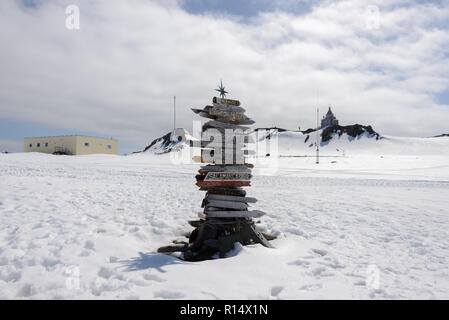 Cartello di direzione con la distanza di diverse città in russo Bellingshausen Antarctic Research Station, sull'isola King George, in Antartide Foto Stock