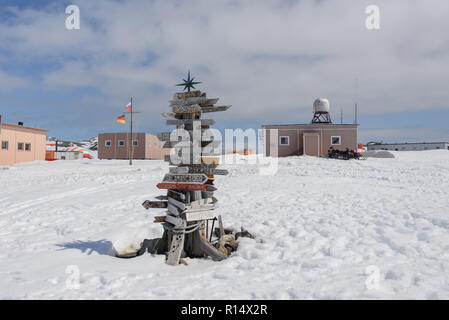 Cartello di direzione con la distanza di diverse città in russo Bellingshausen Antarctic Research Station, sull'isola King George, in Antartide Foto Stock