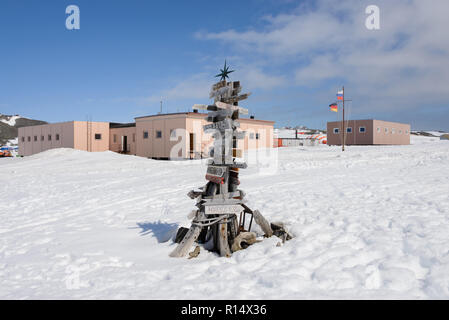 Cartello di direzione con la distanza di diverse città in russo Bellingshausen Antarctic Research Station, sull'isola King George, in Antartide Foto Stock