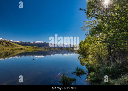 Il lago di Hayes riflettendo Coronet montagne con neve, vicino a Queenstown, Nuova Zelanda Foto Stock