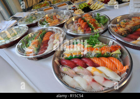 Sushi, Sashimi, rotoli su vassoi e snack freddi essendo preparato per una festa sul tavolo del buffet e catering Foto Stock