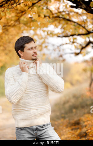 Uomo bello in bianco felpa lavorata a maglia sui giorni di autunno Foto Stock
