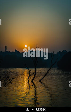 Sun è in aumento a Hauz Khas Lago in autunno Foto Stock