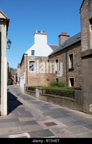 Una vecchia casa di pietra arenaria in Stromness, Orkney con pietre per pavimentazione da una cava locale e ciottoli nel centro della strada. Foto Stock